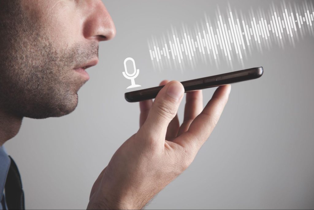 Man, searching for a dentist, speaks into a phone for a voice search.