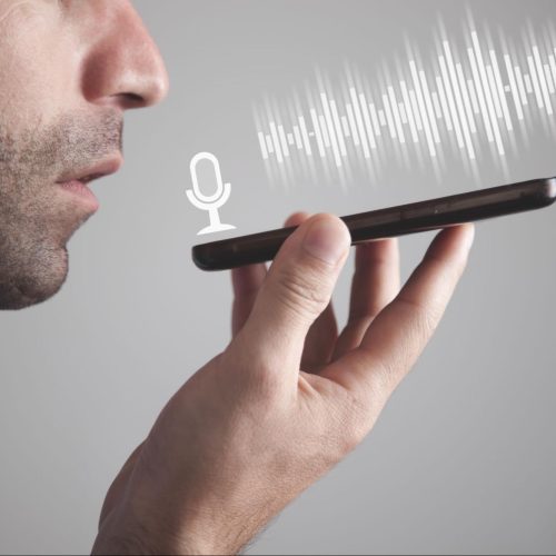 Man, searching for a dentist, speaks into a phone for a voice search.