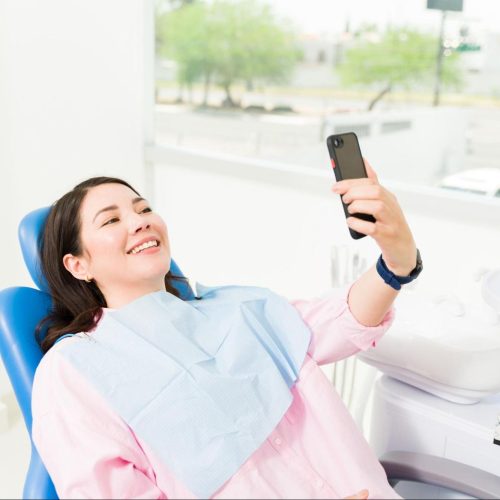 Dental patient checking social media on phone
