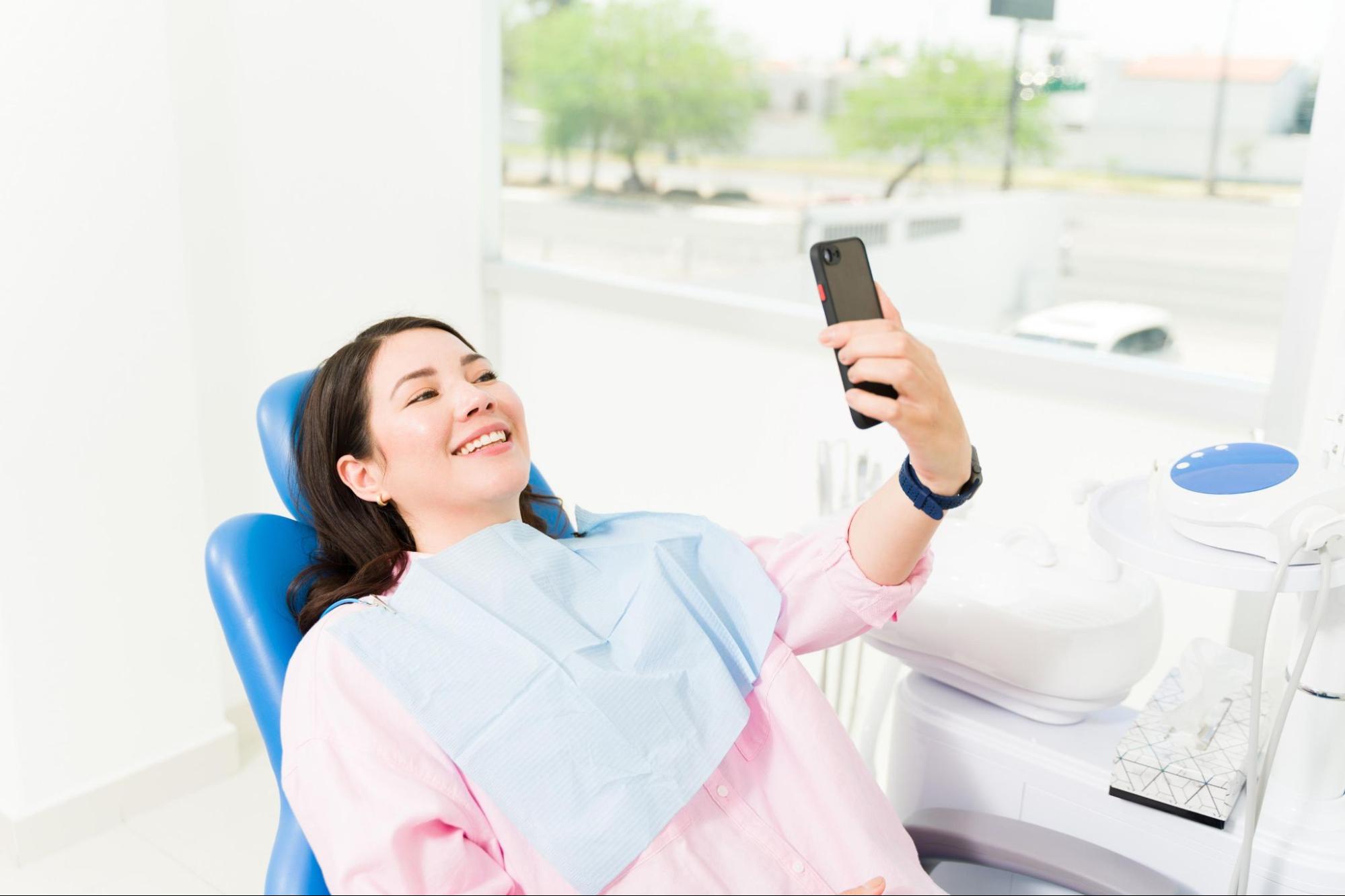 Dental patient checking social media on phone
