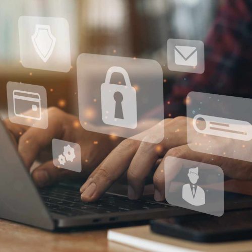 Hands typing on a laptop with floating digital security icons, including a lock and email symbol, conveying cybersecurity and data protection concepts.