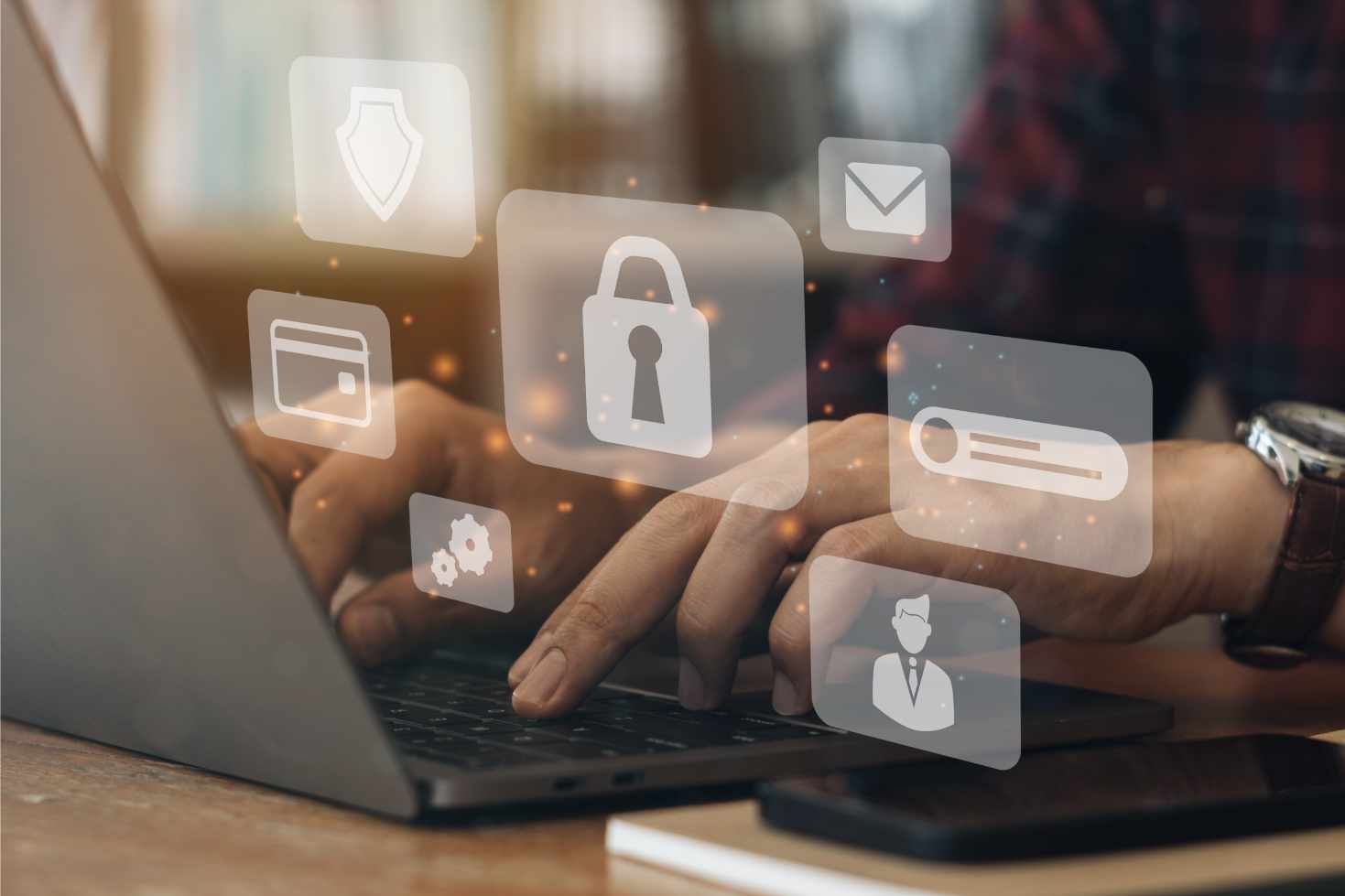 Hands typing on a laptop with floating digital security icons, including a lock and email symbol, conveying cybersecurity and data protection concepts.